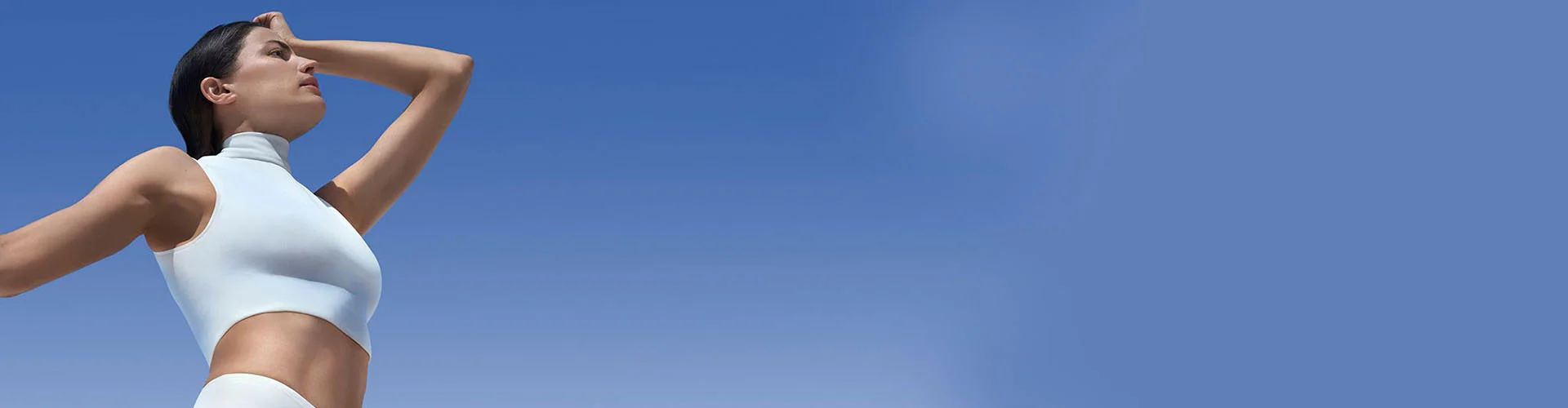 woman wearing white top looking at blue sky