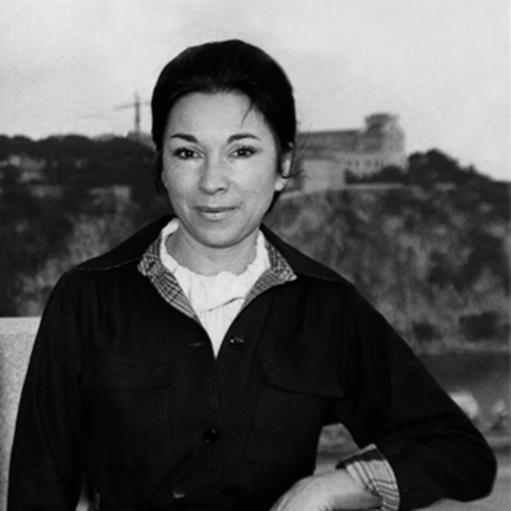 alt="Black and white portrait of Jeanine Marissal, Biotherm's founder, photographed outdoors in Monaco in the 1950s with the Oceanographic Museum visible in the background."